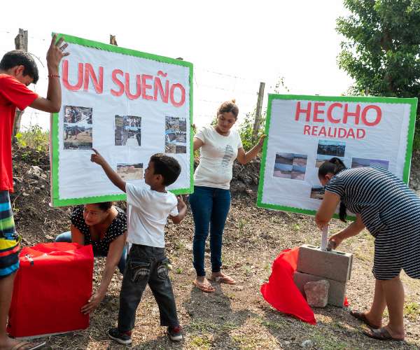Honduras community members hanging a sign in Spanish which translates to "A Dream Come True"