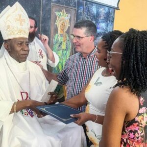 Bishop Burchell is greeted by 3 people who celebrate his retirement