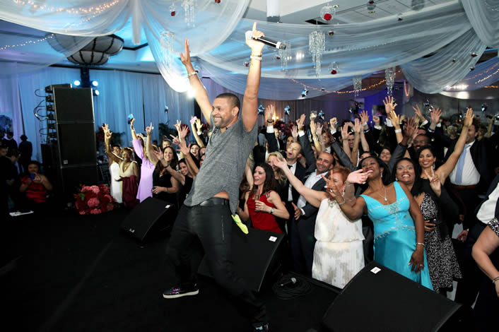 Man on stage in front of crowd at Food For The Poor Event